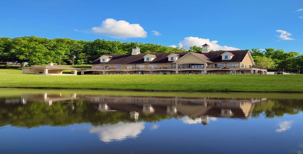 Large lodge for parties with a lake in front of it.