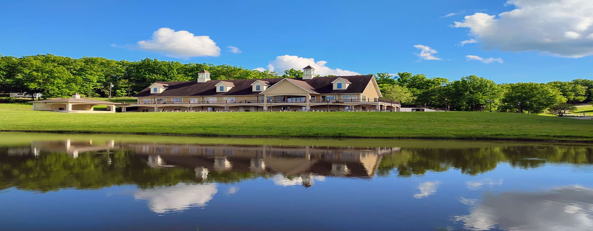 Large lodge for parties with a lake in front of it.