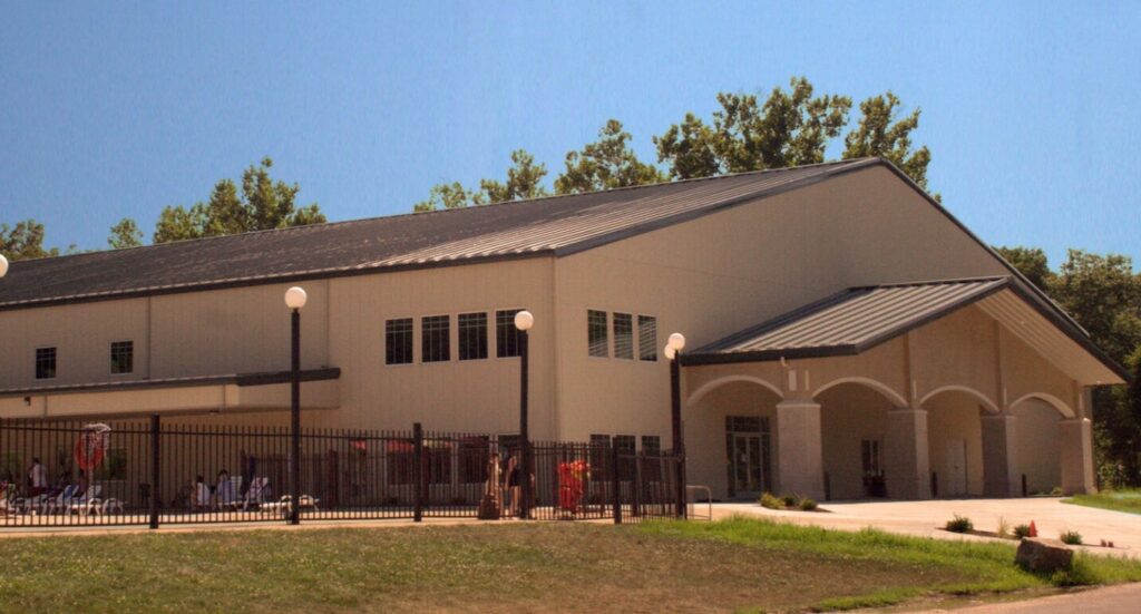 Metal building with a pool next to it where swimming and fun can be had.